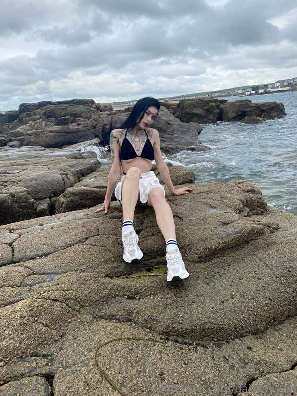 Beside the brooding sea, I stand as a gothic vision in the d..