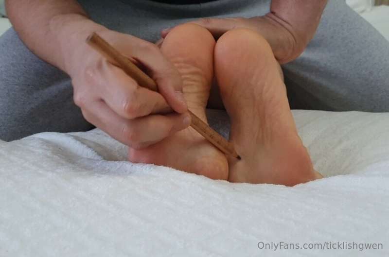 Pencil and glove tickling, feet close-up.