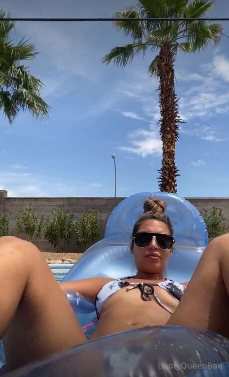 Lying back on my pool float, I slide my bikini to the side a..